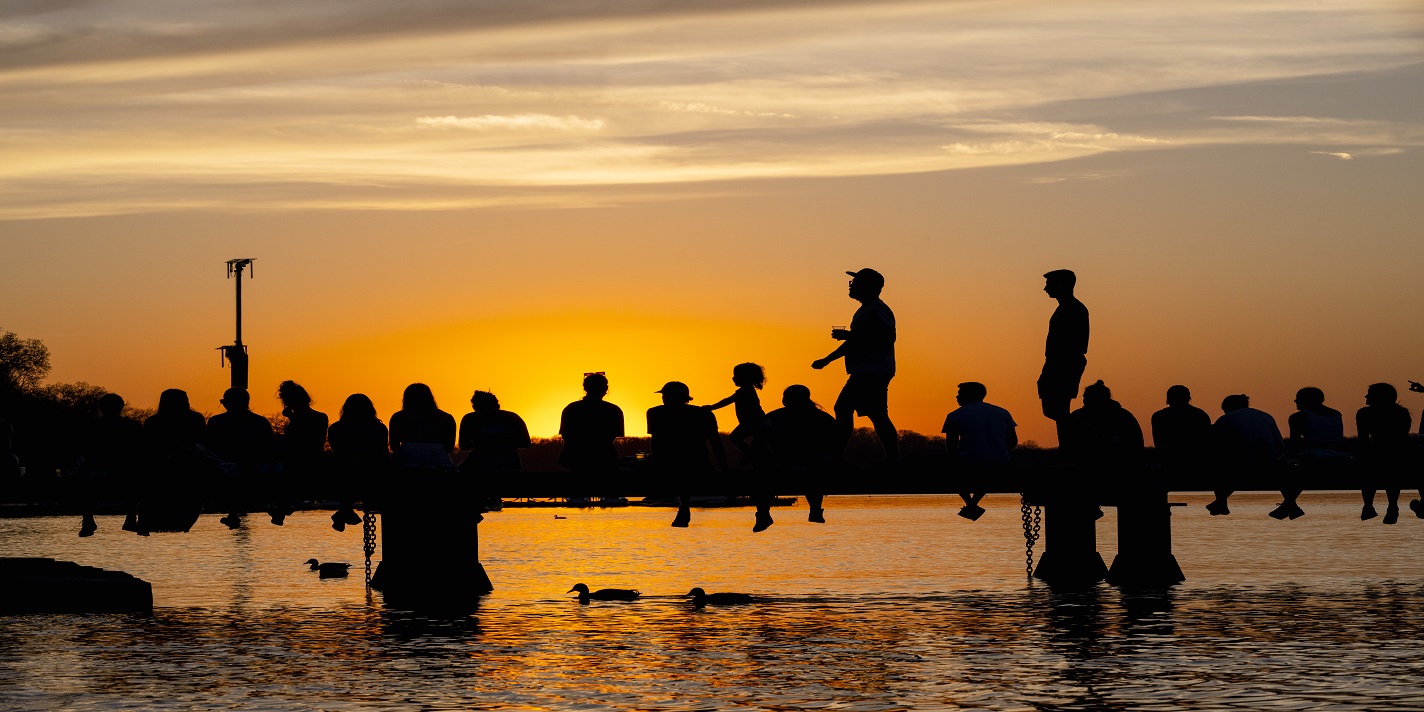 Students and campus community members enjoy the sunset on the Goodspeed Family Pier near the Memorial Union Terrace during sunset during an early spring evening at the University of Wisconsin–Madison on April 13, 2023. (Photo by Taylor Wolfram / UW–Madison)